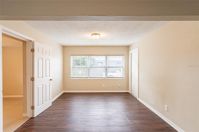 1411 N Powers Dr, Orlando, FL 32818 - empty room with baseboards, a textured ceiling, and dark wood finished floors