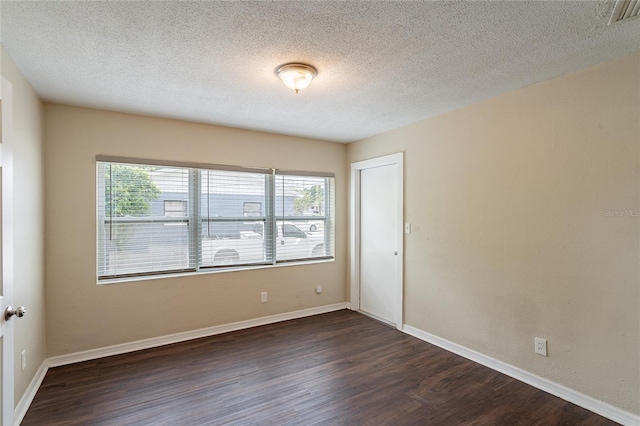 1411 N Powers Dr, Orlando, FL 32818 - spare room featuring a textured ceiling, baseboards, visible vents, and dark wood-style floors