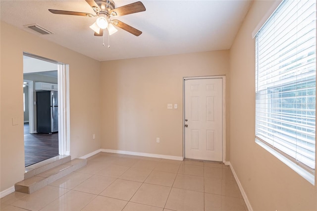 1411 N Powers Dr, Orlando, FL 32818 - empty room featuring baseboards, a ceiling fan, visible vents, and light tile patterned floors