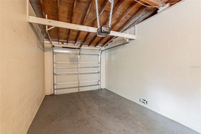 1411 N Powers Dr, Orlando, FL 32818 - garage featuring a garage door opener and concrete block wall