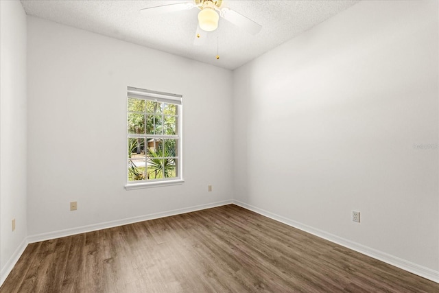 unfurnished room featuring dark wood finished floors, a textured ceiling, a ceiling fan, and baseboards