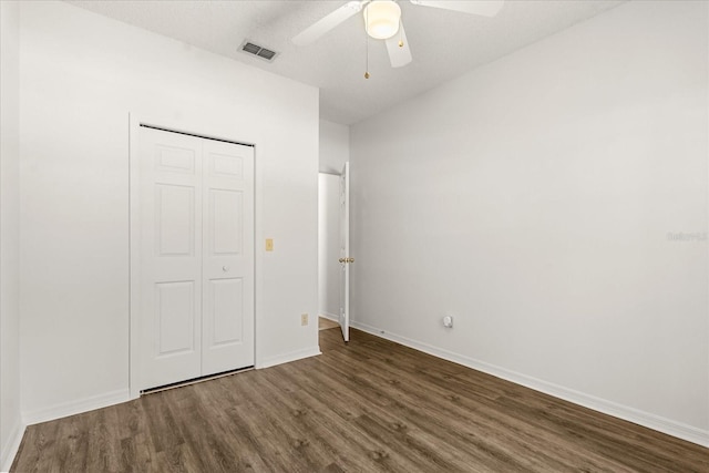 unfurnished bedroom with visible vents, baseboards, a ceiling fan, wood finished floors, and a closet
