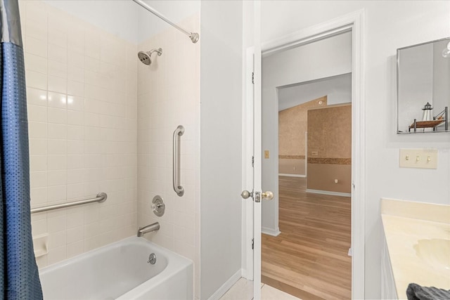 bathroom with shower / tub combo, baseboards, wood finished floors, and vanity