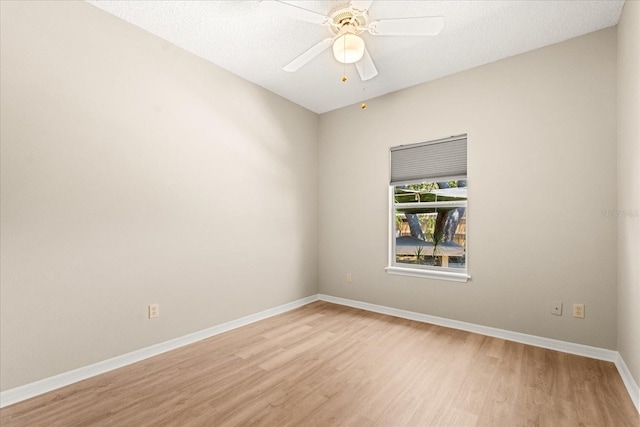 spare room with baseboards, a ceiling fan, and light wood finished floors
