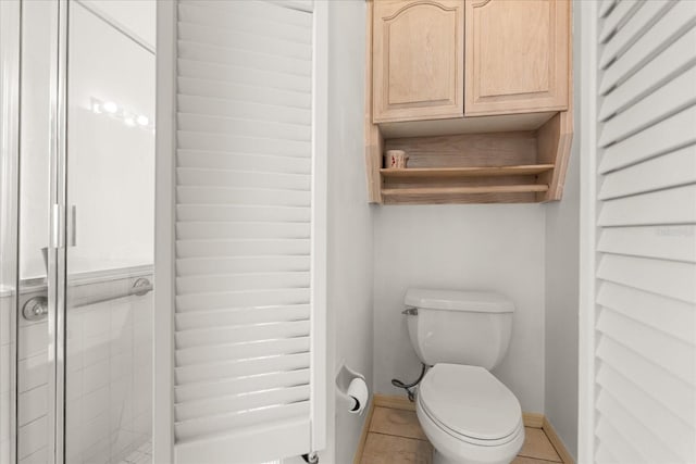 full bath featuring baseboards, tile patterned flooring, a shower stall, and toilet