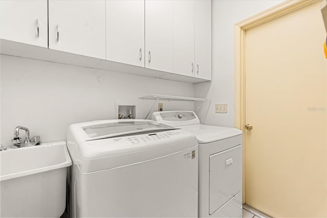 washroom with separate washer and dryer, a sink, and cabinet space