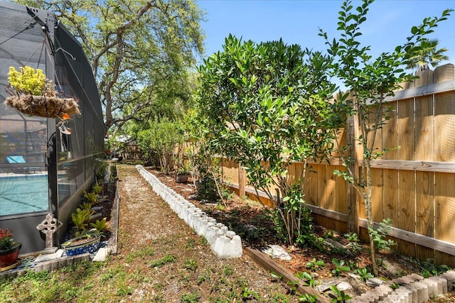 view of yard featuring a fenced backyard, a pool, and glass enclosure