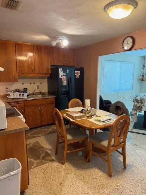 116 E Palm Way, Edgewater, FL 32132 - kitchen with visible vents, a sink, brown cabinets, and black fridge