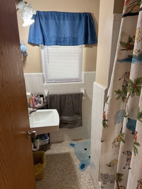 116 E Palm Way, Edgewater, FL 32132 - bathroom with a shower with curtain, tile walls, a sink, and wainscoting