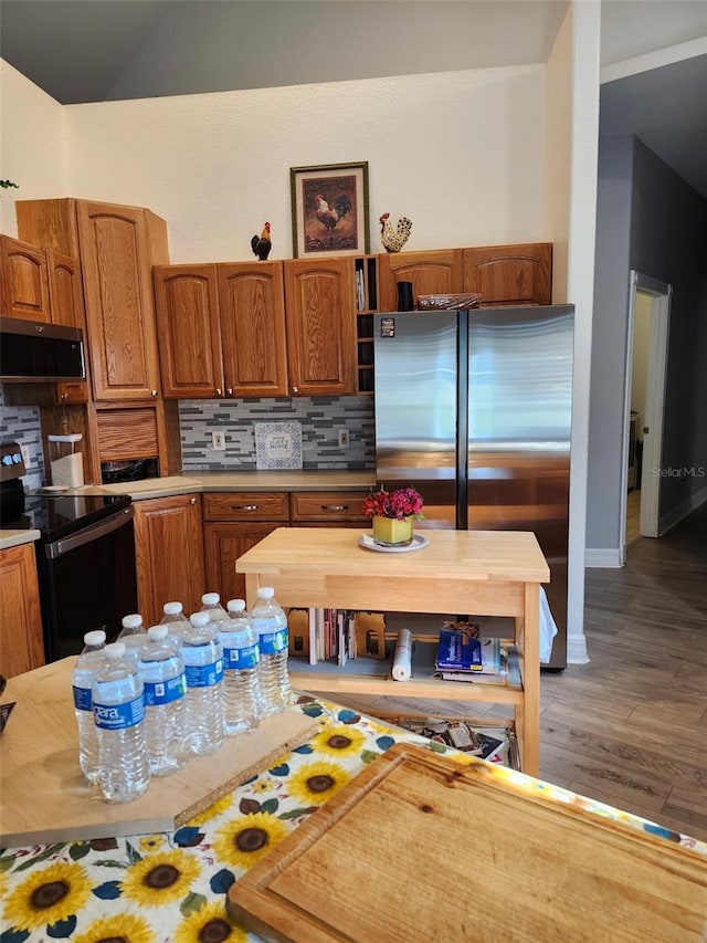 4666 Clarke St, North Port, FL 34286 - kitchen with black range with electric stovetop, freestanding refrigerator, backsplash, and wood finished floors