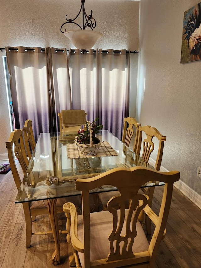 4666 Clarke St, North Port, FL 34286 - dining area featuring hardwood / wood-style flooring, baseboards, a textured wall, and a textured ceiling