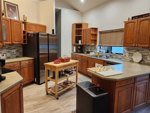 4666 Clarke St, North Port, FL 34286 - kitchen with open shelves, freestanding refrigerator, a sink, backsplash, and lofted ceiling