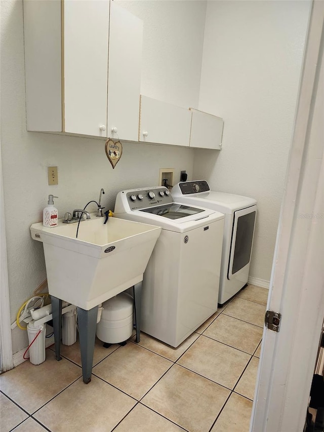 4666 Clarke St, North Port, FL 34286 - washroom featuring washing machine and clothes dryer, cabinet space, and light tile patterned floors