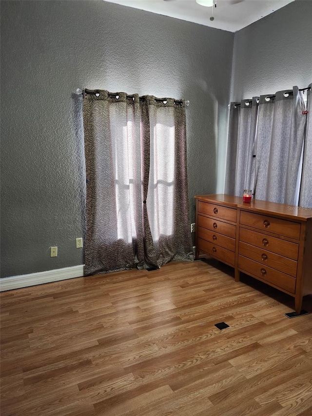 4666 Clarke St, North Port, FL 34286 - bedroom featuring a textured wall, wood finished floors, and baseboards