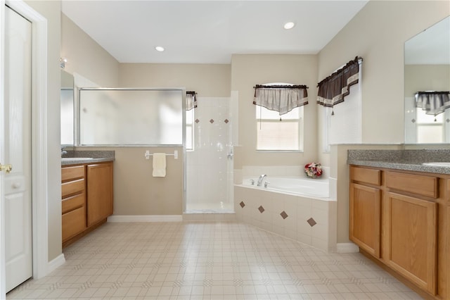 bathroom with two vanities, a garden tub, a stall shower, and a sink
