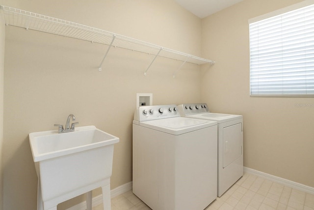 laundry area featuring separate washer and dryer, baseboards, a sink, and laundry area