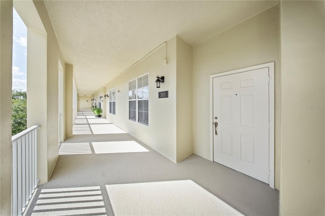 property entrance with stucco siding and a balcony