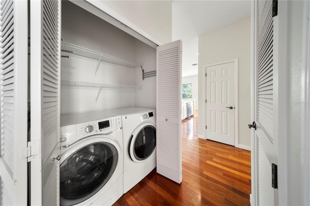 washroom featuring washing machine and dryer, dark wood-style flooring, and laundry area