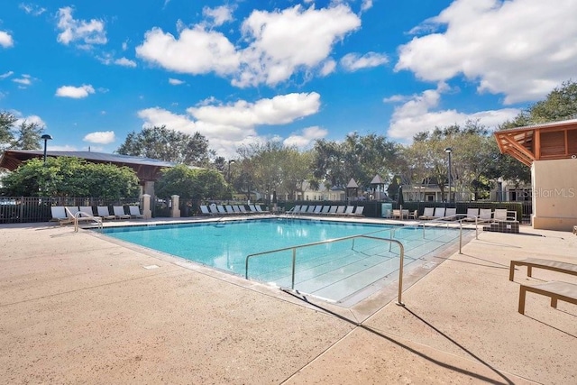 community pool featuring fence and a patio