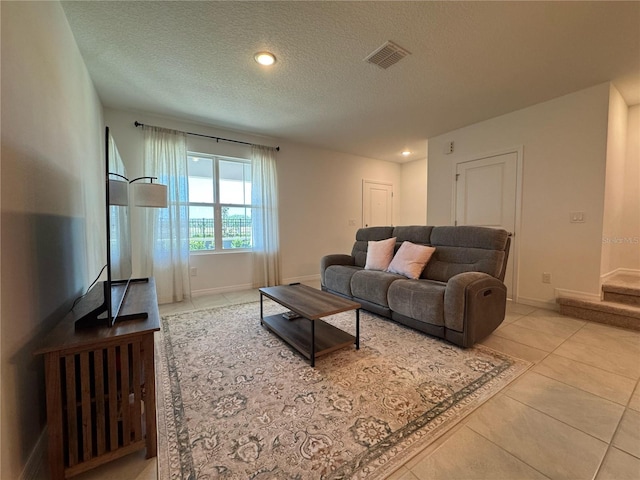 tiled living room featuring visible vents, baseboards, recessed lighting, and a textured ceiling