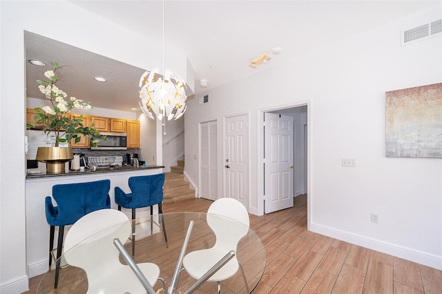 4011 Venetian Bay Dr Unit 103, Kissimmee, FL 34741 - dining space featuring visible vents, baseboards, an inviting chandelier, and light wood-style flooring