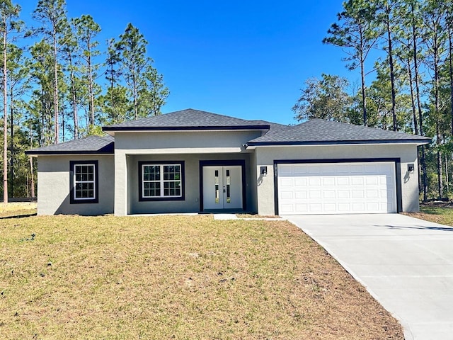 view of front of house with stucco siding, a front lawn, driveway, and a garage