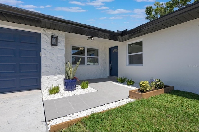 doorway to property with stucco siding and a garage