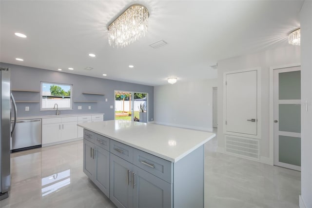 kitchen featuring stainless steel dishwasher, a center island, recessed lighting, open shelves, and light countertops