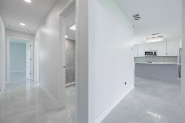 hall featuring attic access, baseboards, visible vents, and recessed lighting