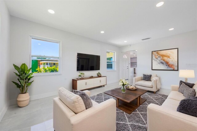 living room featuring baseboards, visible vents, and recessed lighting