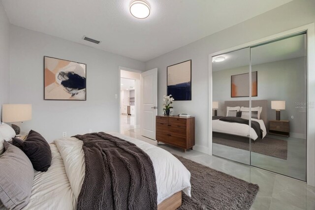 bedroom featuring baseboards, visible vents, and a closet