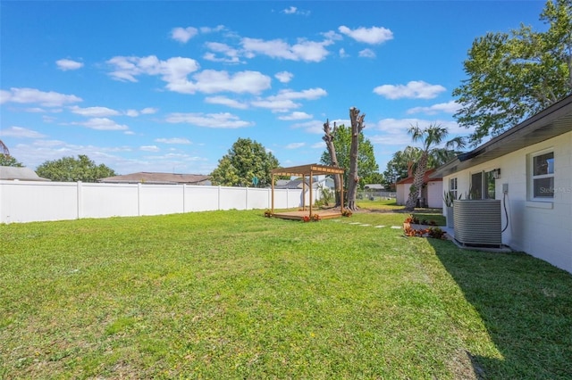 view of yard featuring central AC, a fenced backyard, and a deck