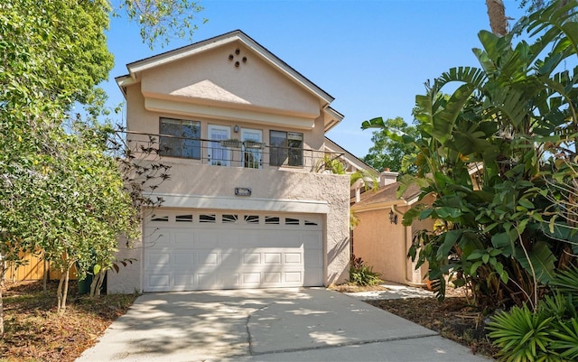 view of front of property featuring stucco siding, concrete driveway, a balcony, and a garage
