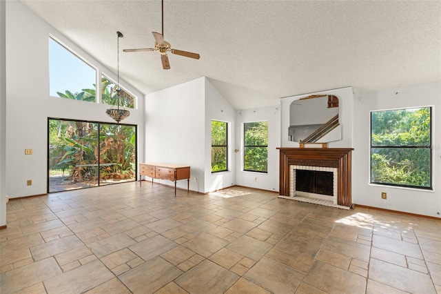 unfurnished living room with a textured ceiling, baseboards, a ceiling fan, a brick fireplace, and high vaulted ceiling