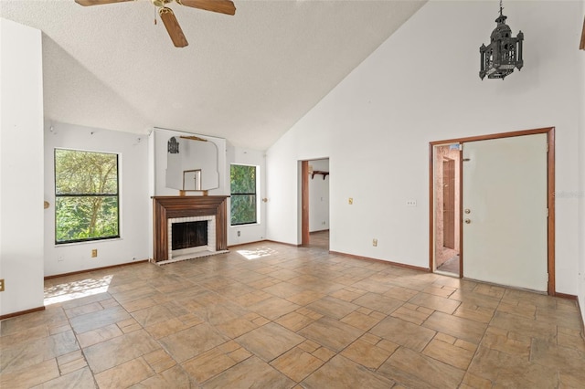 unfurnished living room with high vaulted ceiling, stone tile floors, ceiling fan, baseboards, and a brick fireplace