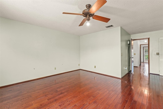 unfurnished room featuring hardwood / wood-style flooring, visible vents, a textured ceiling, and a ceiling fan