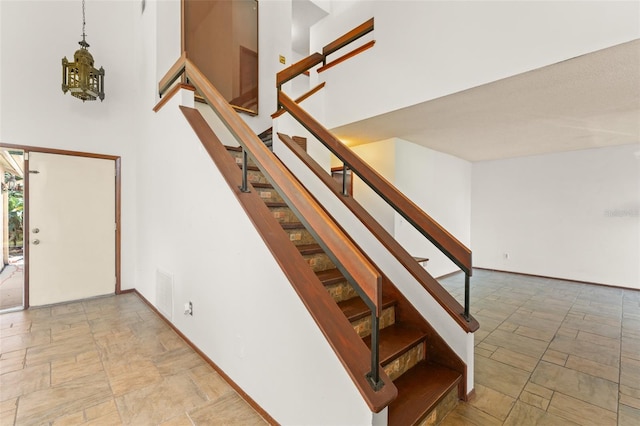 stairs featuring stone finish flooring, baseboards, and visible vents