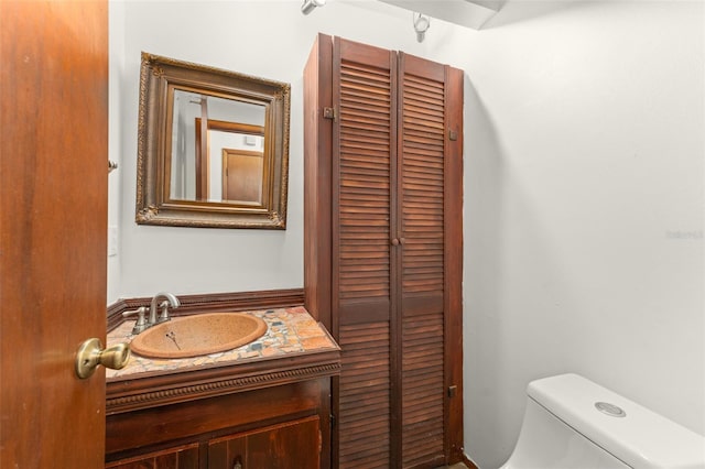 half bath featuring vanity and toilet