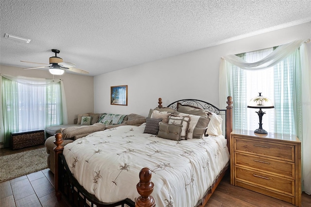 bedroom with visible vents, a ceiling fan, a textured ceiling, and wood finished floors