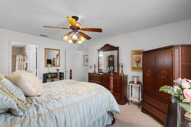 bedroom with a ceiling fan, a textured ceiling, visible vents, and light carpet
