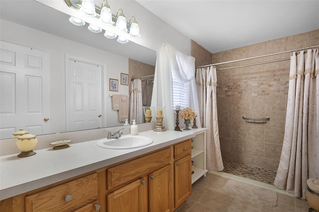 bathroom with tile patterned floors, tiled shower, and vanity