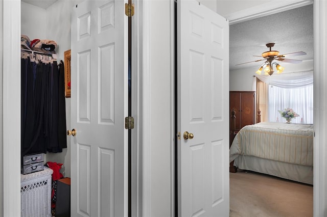 bedroom with a ceiling fan, a textured ceiling, and carpet