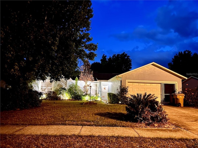 ranch-style home featuring an attached garage, stucco siding, and concrete driveway