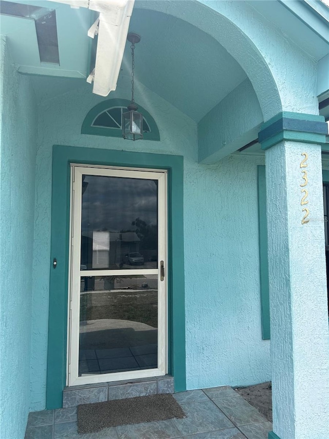 doorway to property featuring stucco siding