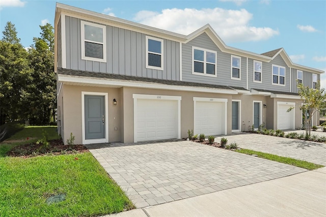1409 Fan Palm Dr, Davenport, FL 33897 - townhome / multi-family property featuring a garage, decorative driveway, and stucco siding