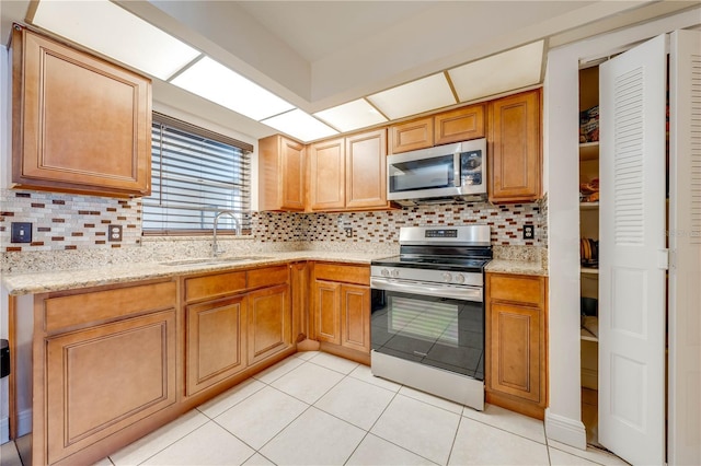 194 Larkspur Ct, Kissimmee, FL 34743 - kitchen with a sink, light tile patterned floors, stainless steel appliances, backsplash, and light stone countertops