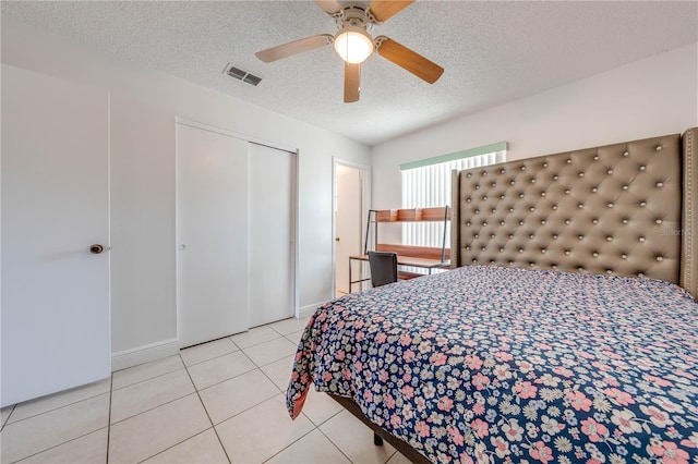 194 Larkspur Ct, Kissimmee, FL 34743 - tiled bedroom with a ceiling fan, a textured ceiling, a closet, baseboards, and visible vents