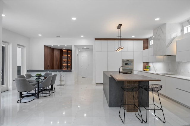 10849 Emerald Chase Dr, Orlando, FL 32836 - kitchen featuring modern cabinets, a kitchen breakfast bar, white cabinets, a center island with sink, and recessed lighting