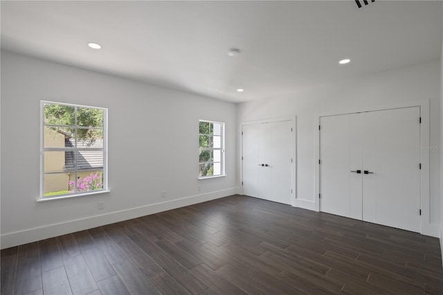 10849 Emerald Chase Dr, Orlando, FL 32836 - unfurnished bedroom featuring two closets, dark wood-style flooring, and recessed lighting