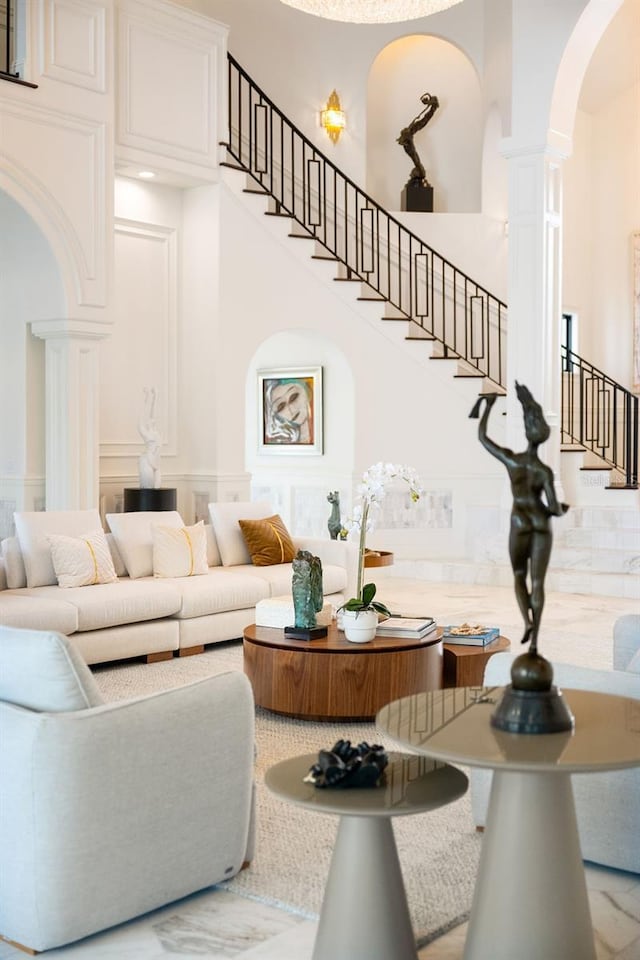570 Manor Rd, Maitland, FL 32751 - living room featuring decorative columns, a towering ceiling, arched walkways, and stairway